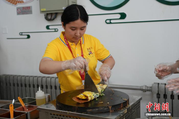 8月6日，华裔营员在天津体验煎饼馃子制作。　（天津师范大学供图）
